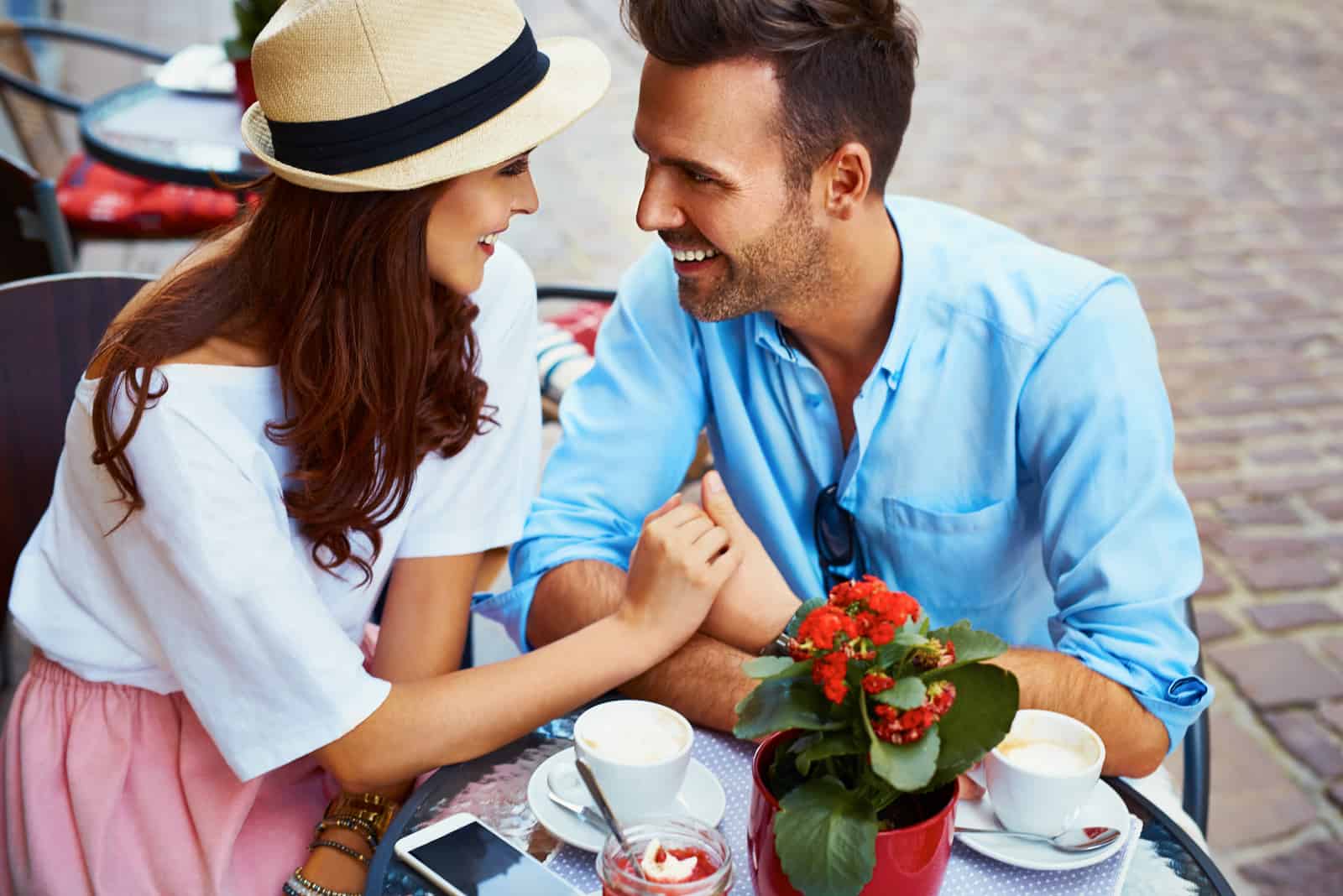 Par som är förälskade att sitta i kafé som ser varandra