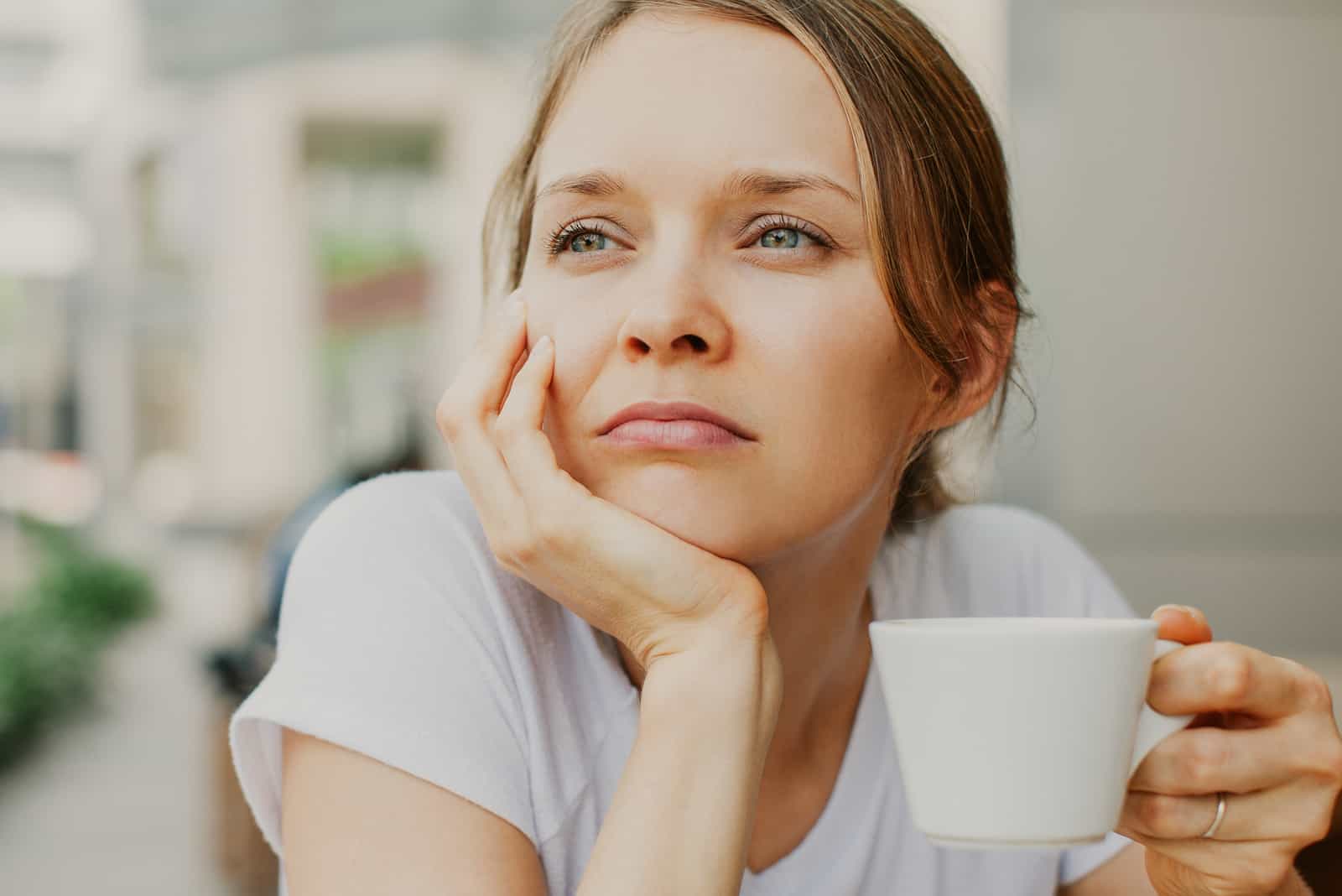 fundersam ung vacker kvinna som dricker kaffe