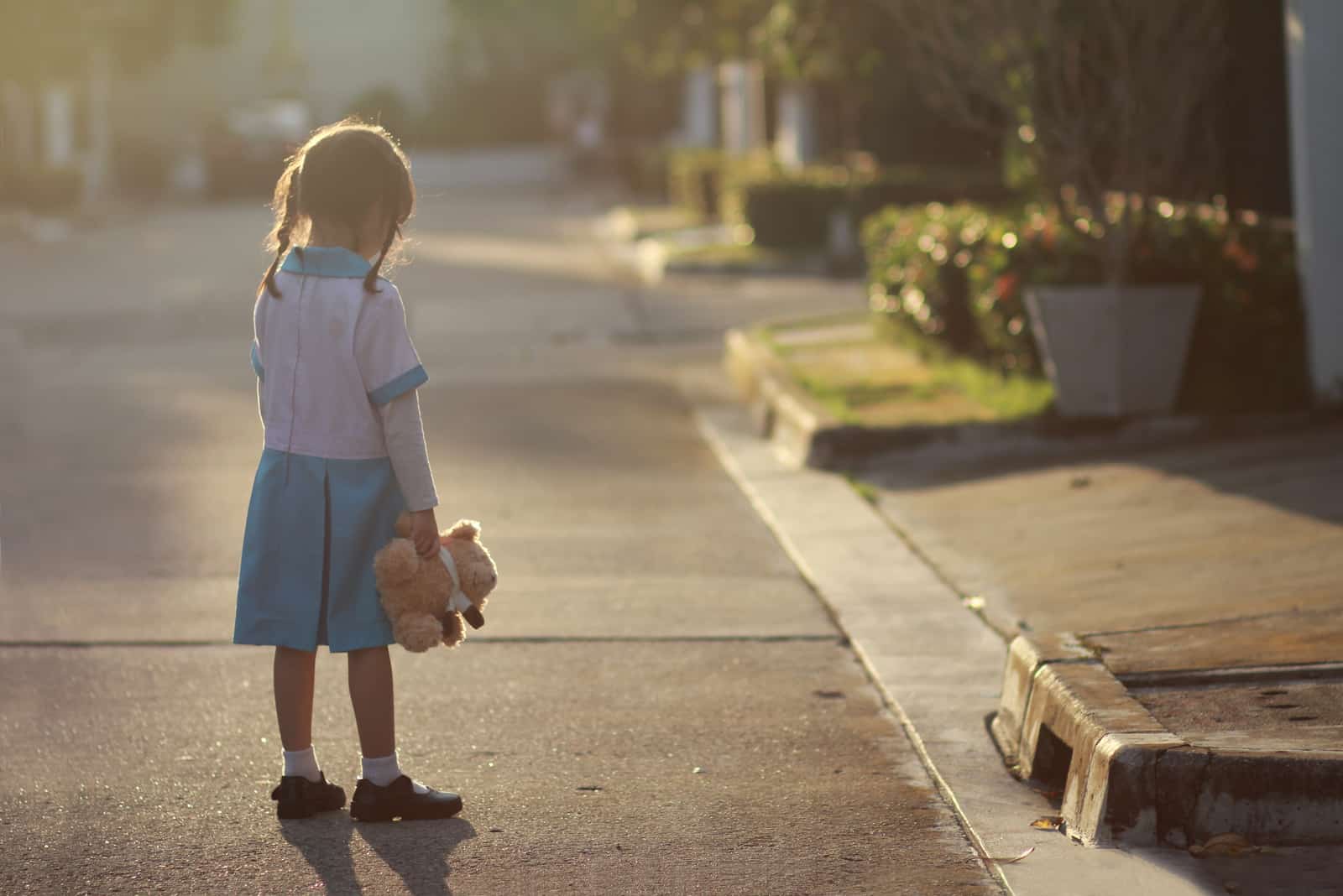 liten flicka stå ensam på gatan