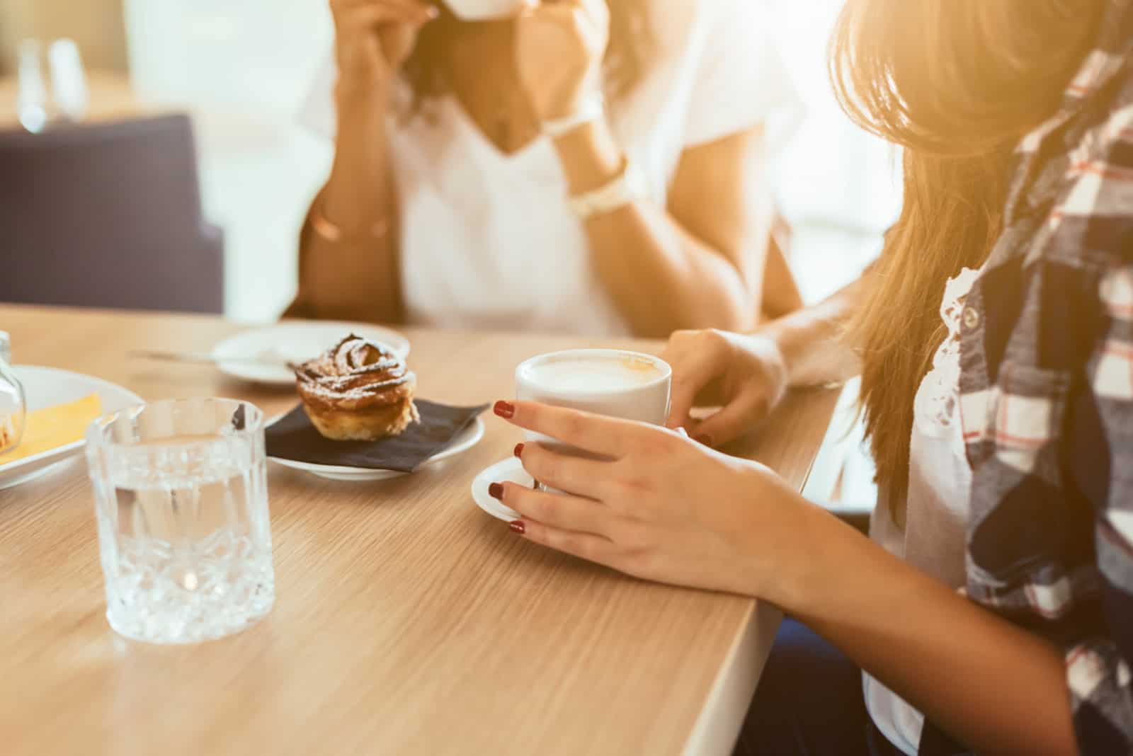 två kvinnavänner som tar kaffe på kaféet