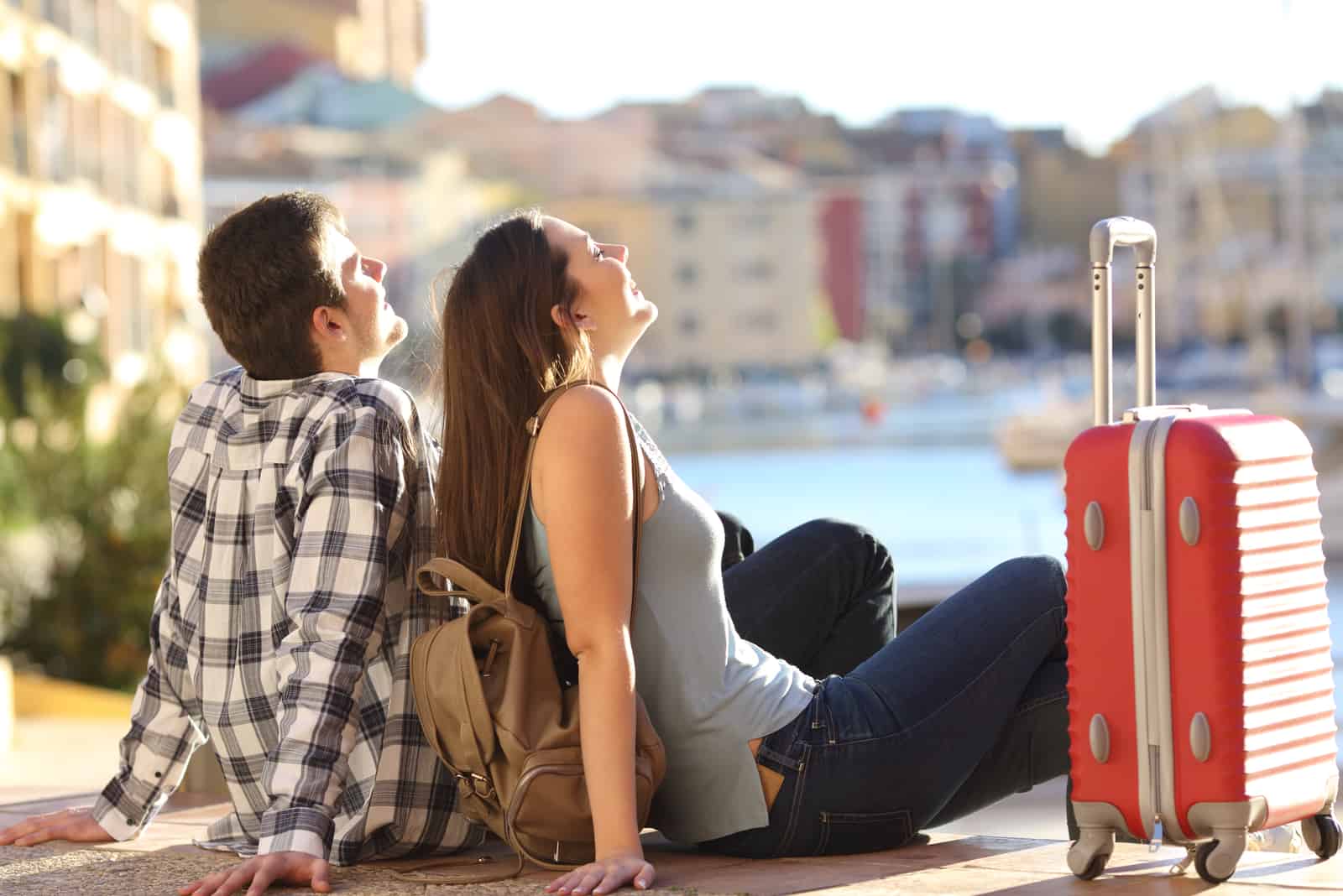 par av 2 turister med en resväska som sitter avkopplande