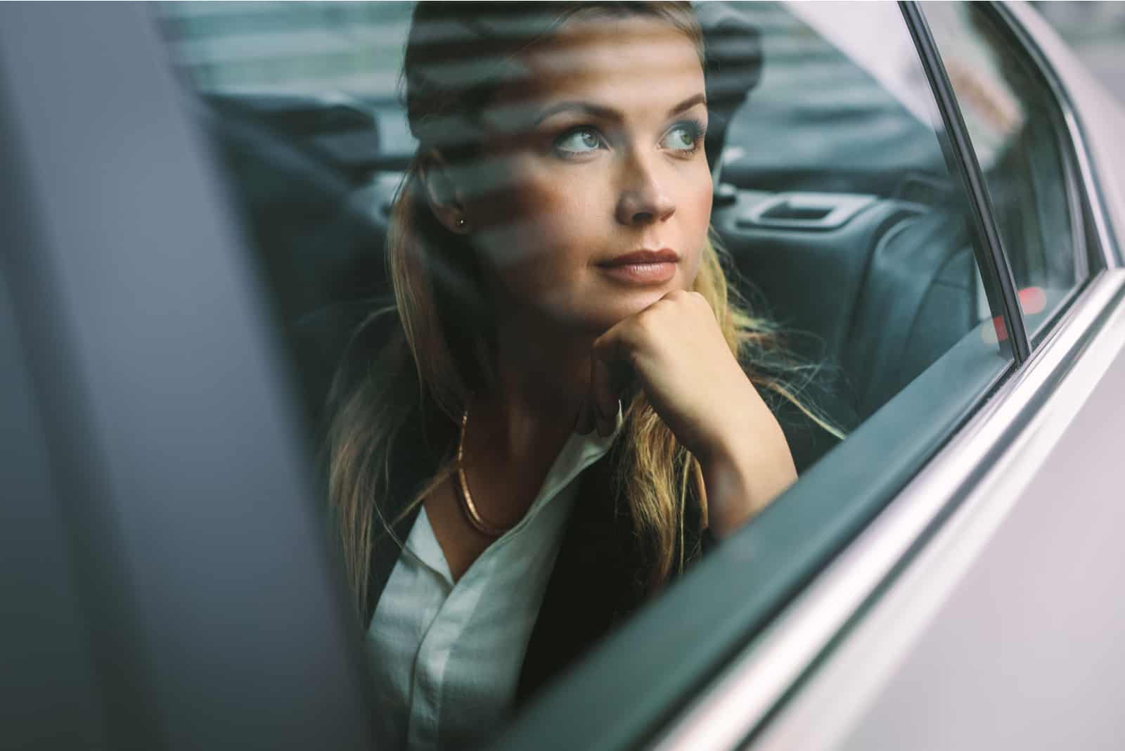 ung affärskvinnasammanträde på baksätet i en bil