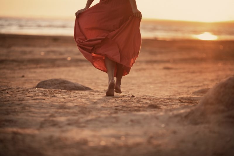 kvinna som går på stranden ensam