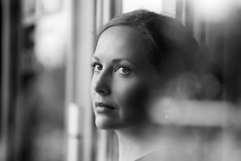 kvinna som står vid fönstret