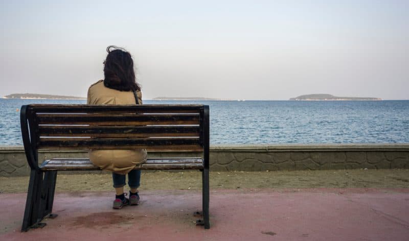 ledsen deprimerad kvinna sitter ensam på bänken