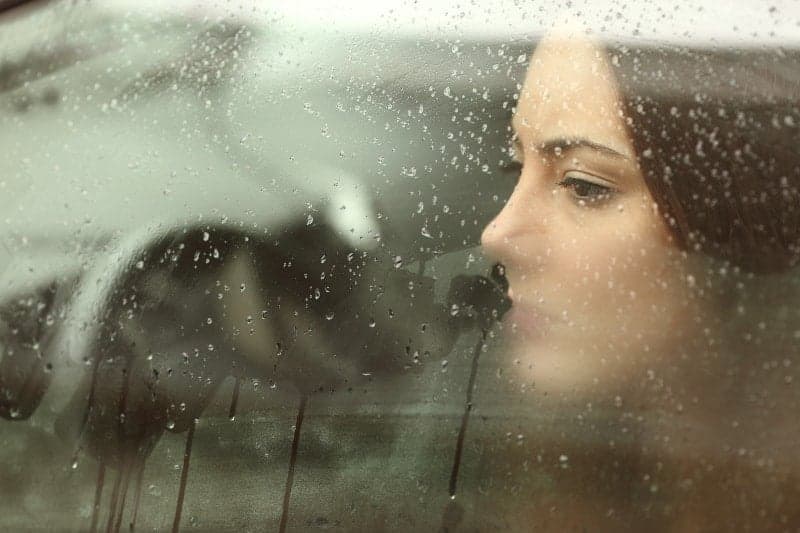 sorglig kvinna som tittar ut genom bilfönstret