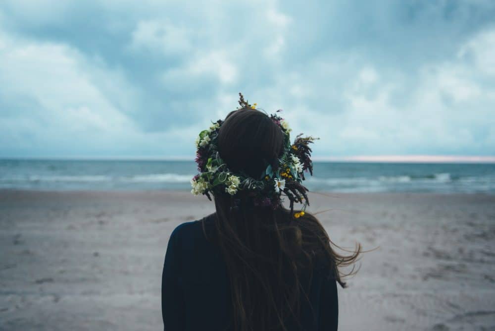 flicka som står ensam på stranden