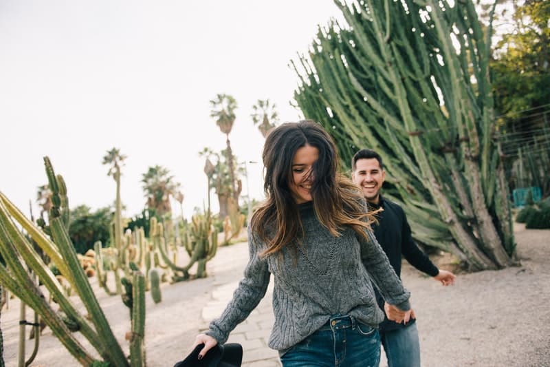 man och kvinna springer nära kaktusar