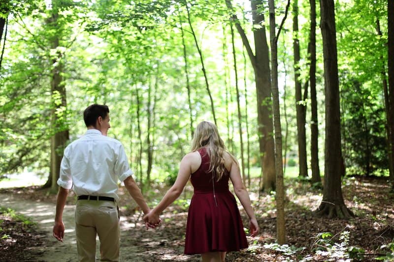kvinna och man som går i skogen medan de håller händer