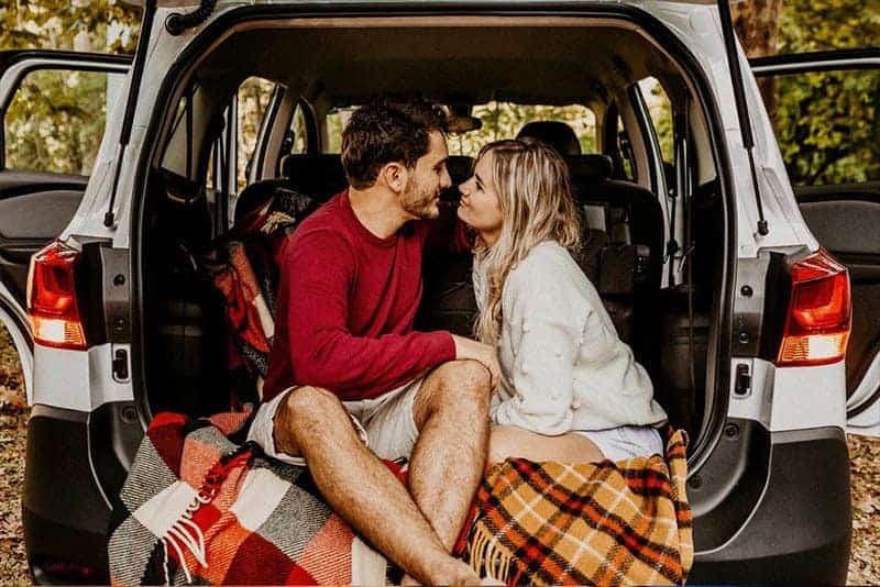 romantisk man och kvinna som har picknick i bilen