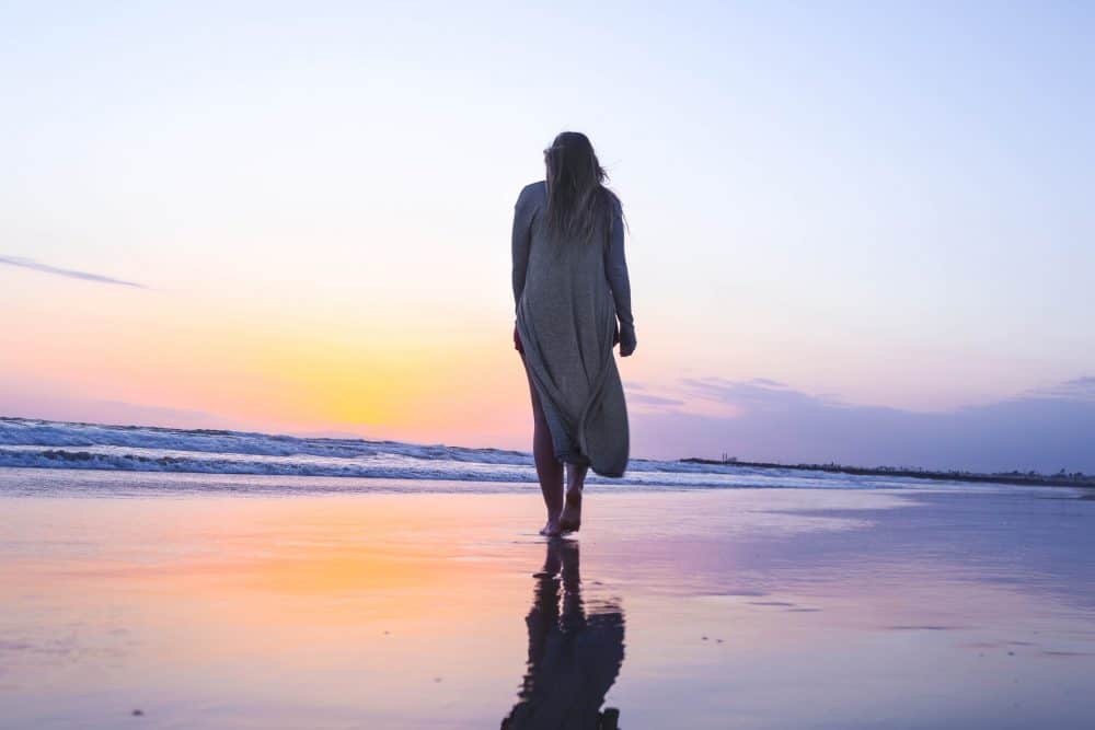 kvinna som går ensam på stranden