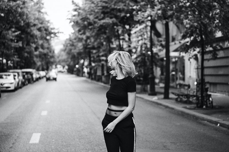 kvinna i svart skjorta som går på gatan