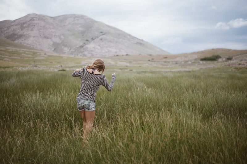 kvinna som går på gräset ensam