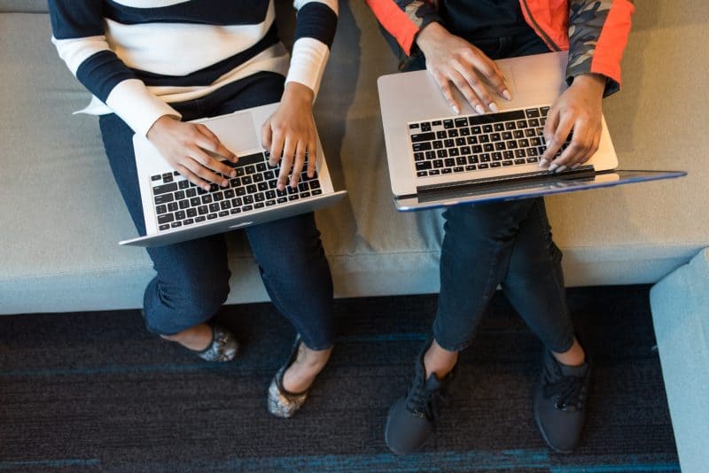 två kvinnor som använder bärbara datorer