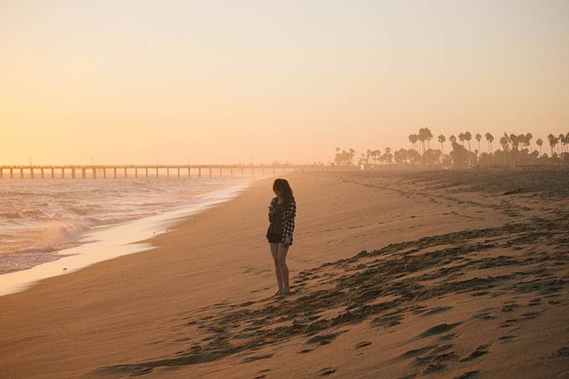 kvinna som står ensam på stranden