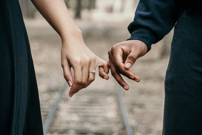 man och kvinna som håller fingrar