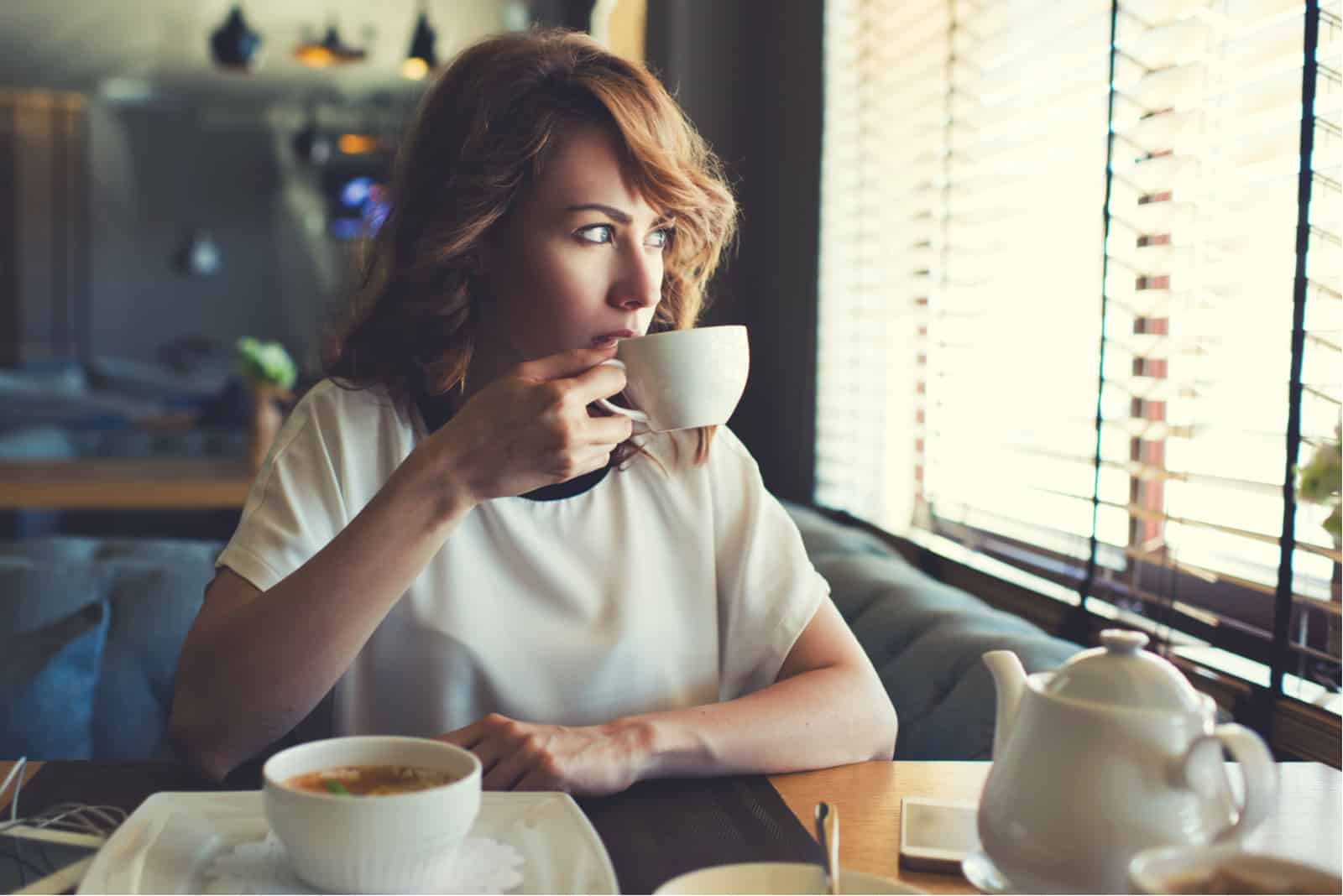kvinna sitter på café dricka kaffe