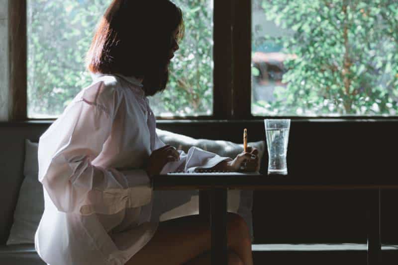 kvinna skriver ett brev vid bordet