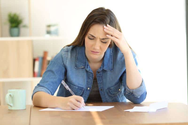 olycklig kvinna som skriver ett brev hemma