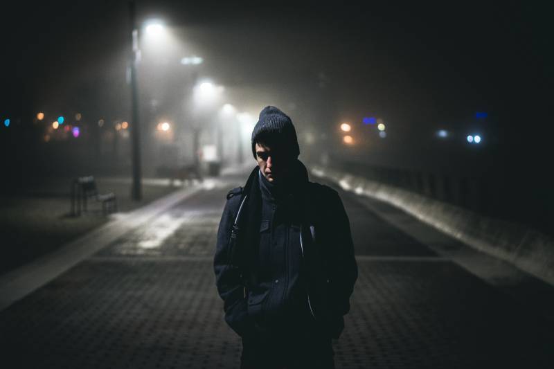 Man som står i gatalampor under natten