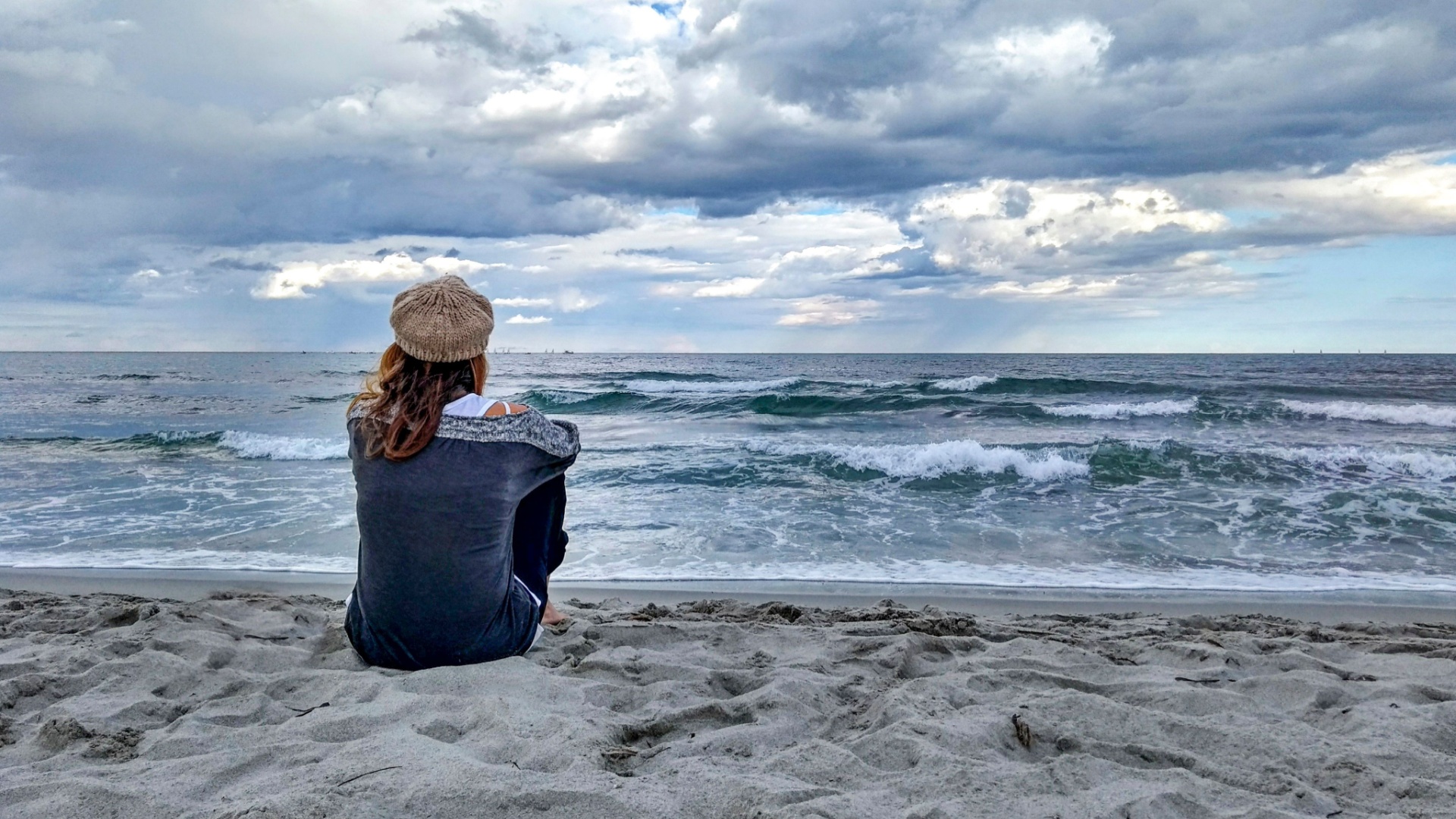 ung kvinna sitter pae en strand