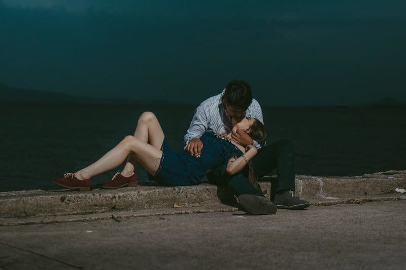 ett kärleksfullt par som kysser på en betongbrygga