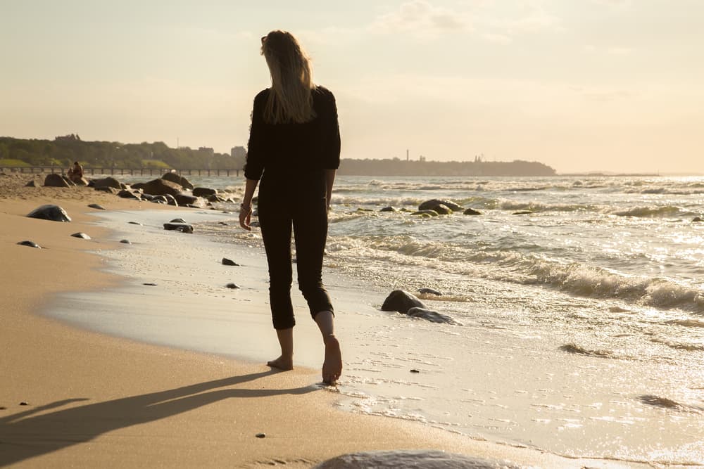 kvinna som går ensam på stranden