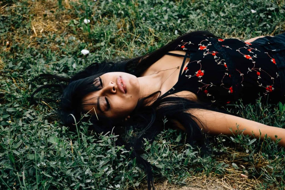 vacker kvinna som ligger på gräset