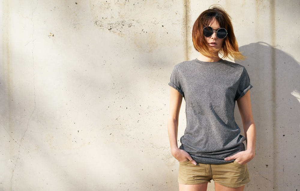 attraktiv ung kvinna klädd i en grå blank t-shirt