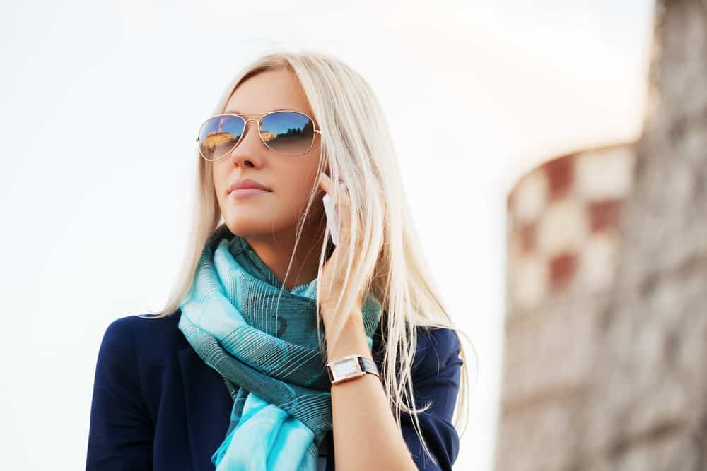 blond kvinna med solglasögon prata i telefon