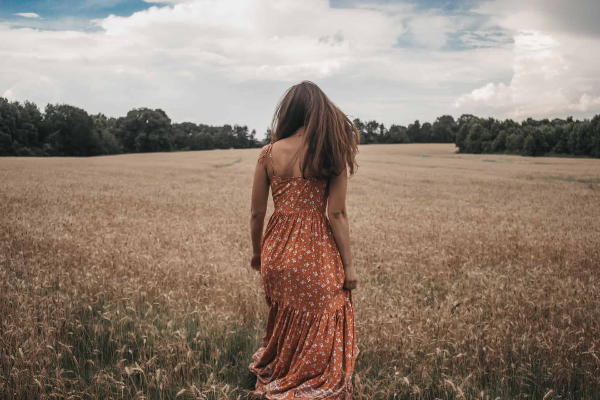 kvinna i orange klänning i fältet