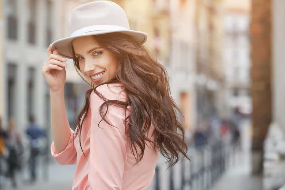 kvinna med hatt poserar på gatan