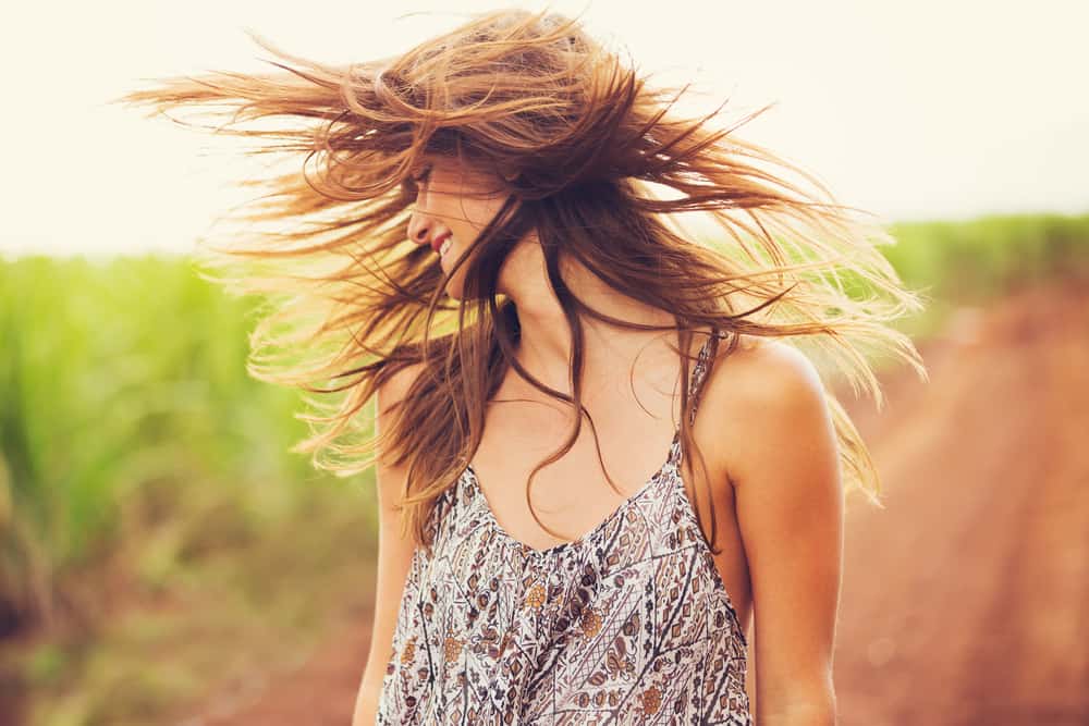 kvinna poserar med hår som blåser i vinden
