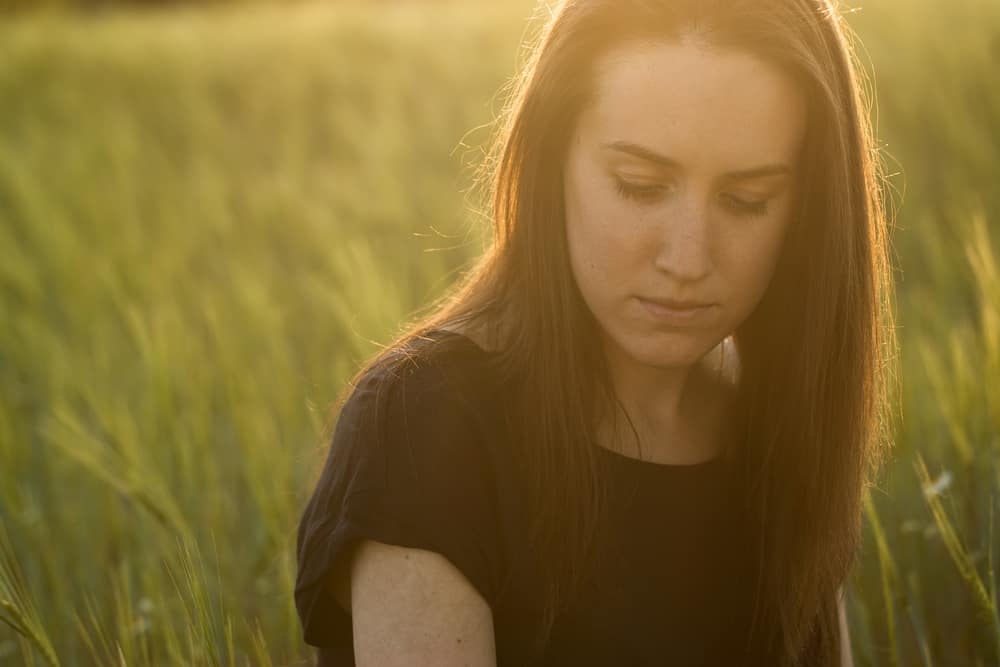 ledsen kvinna i gräsfält