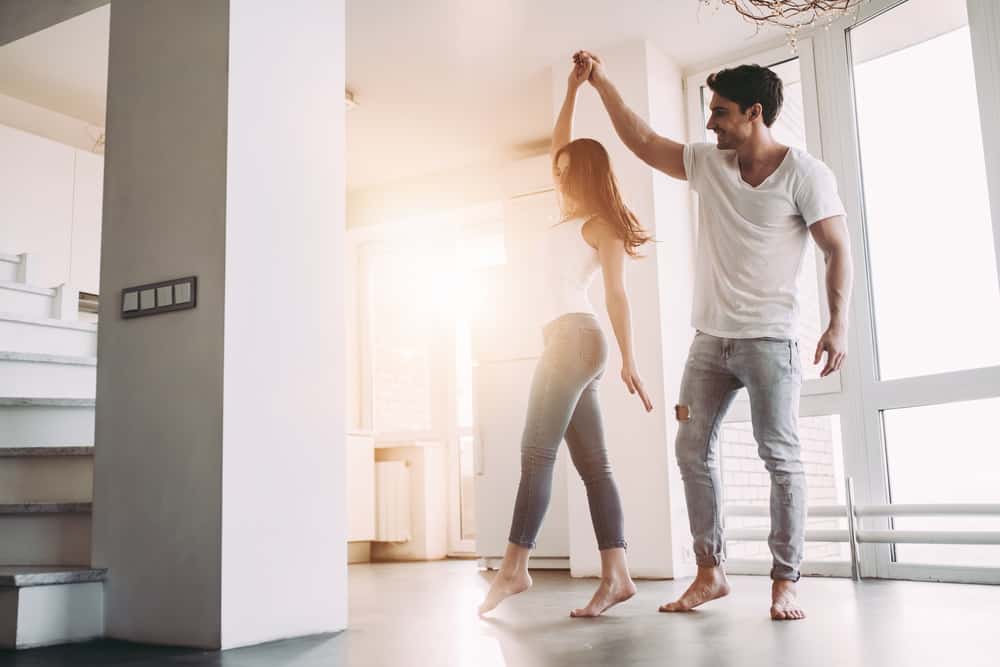 man och kvinna dansar hemma