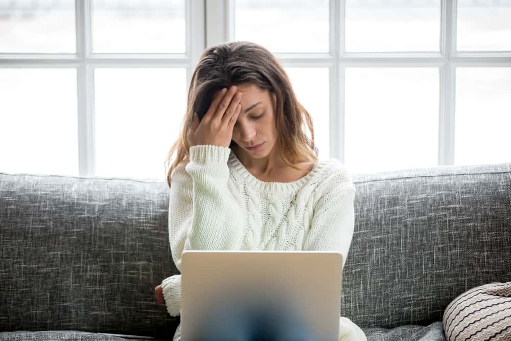 stressad kvinna tittar på bärbar dator