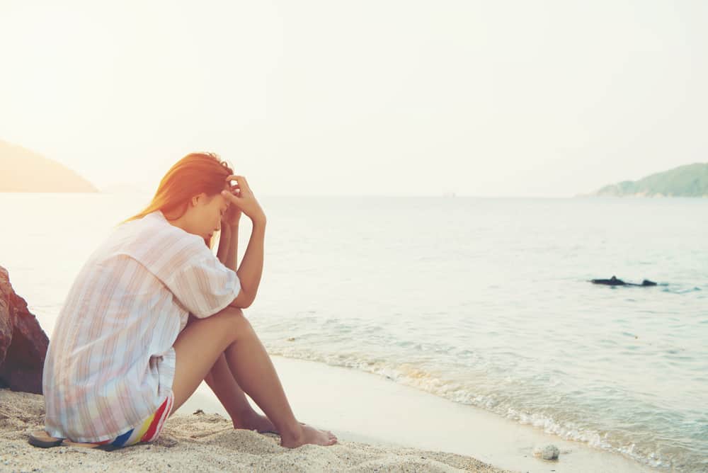 ung kvinna på stranden ledsen