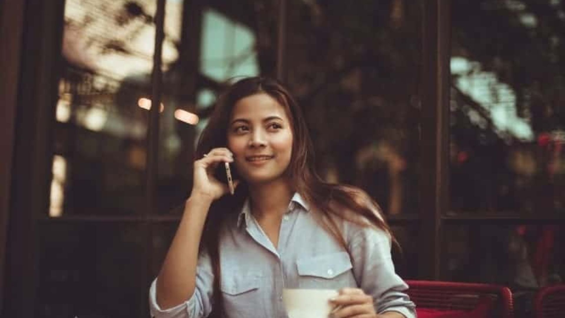 kvinna pratar i telefon i café