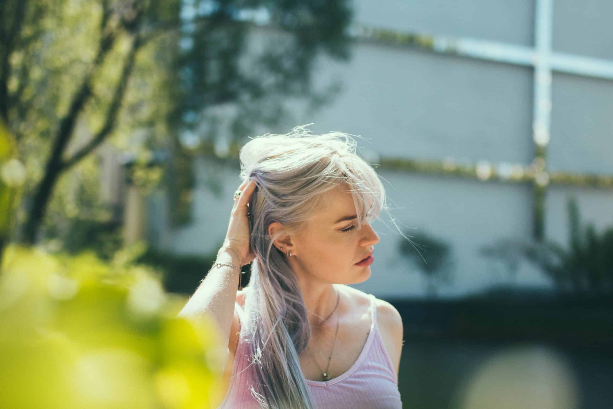 blond kvinna som håller håret