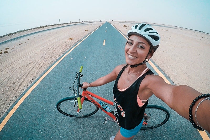 en kvinna med en cykel på vägen tar ett selfie-foto