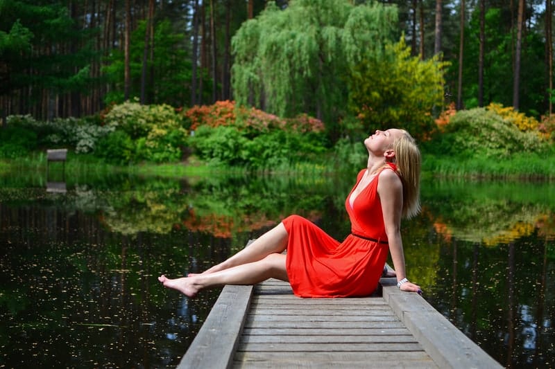 kvinna njuter och sitter nära sjön