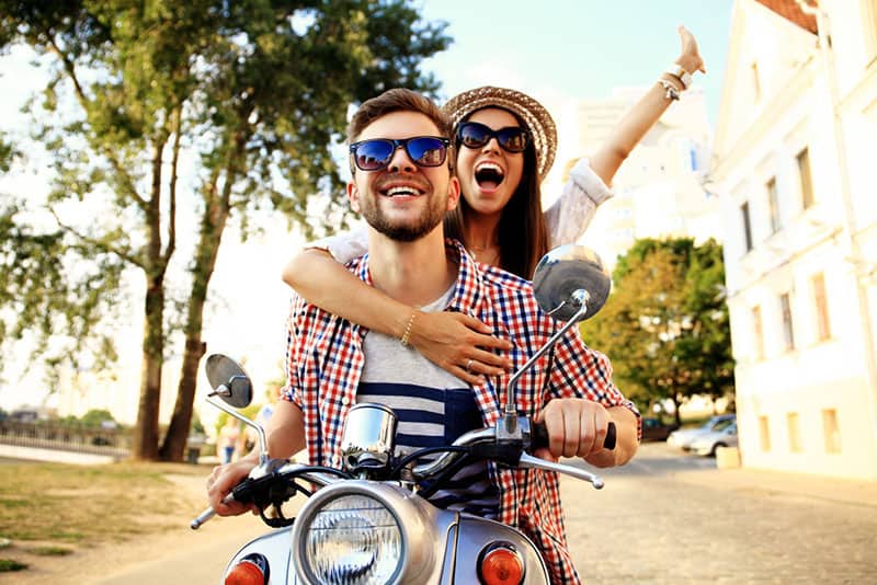 lyckliga par som kör på motorcykel