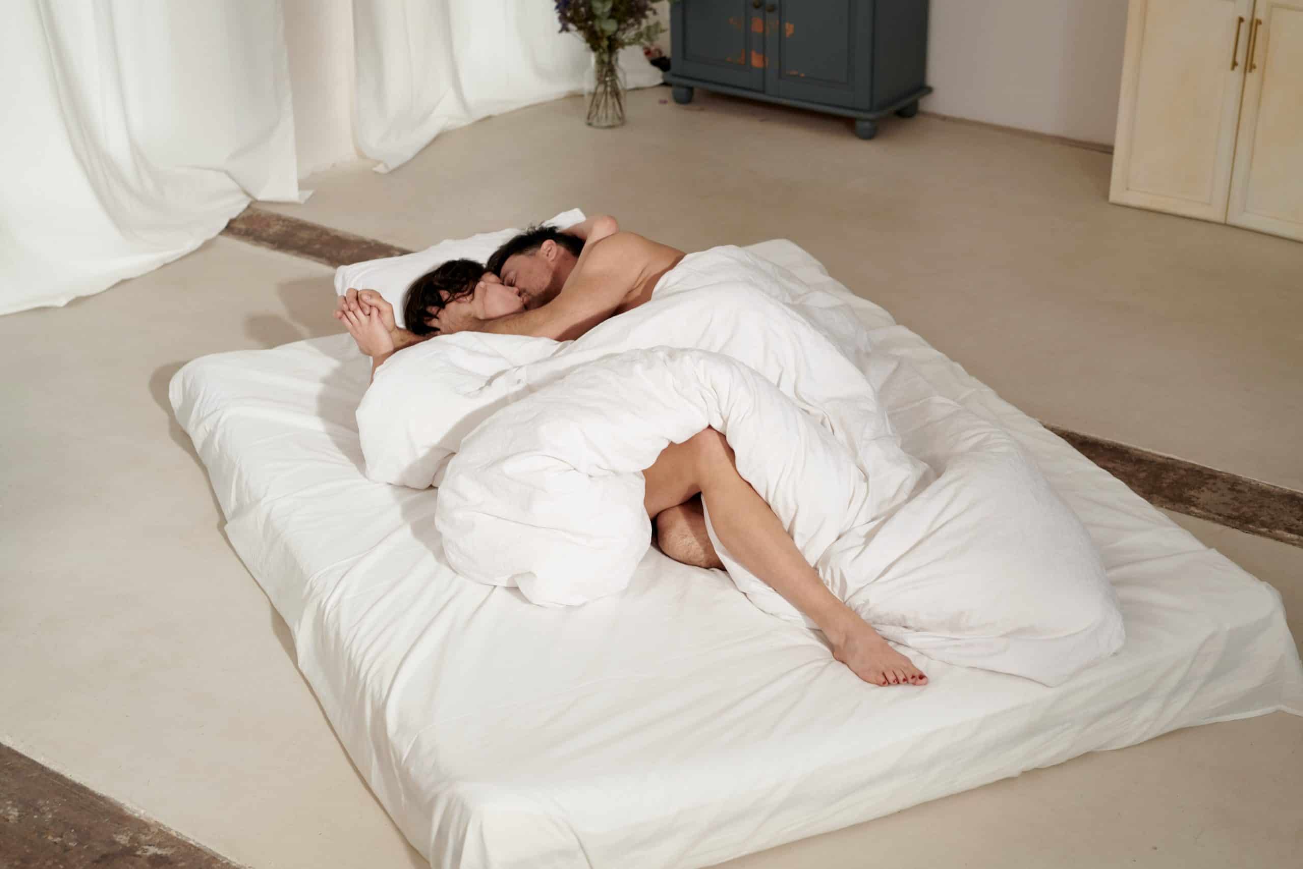 man och kvinna kela i sängen