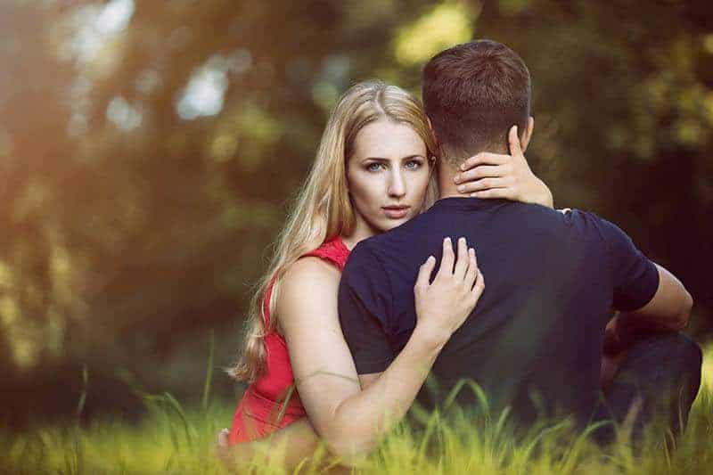 man och kvinna kram i gräset