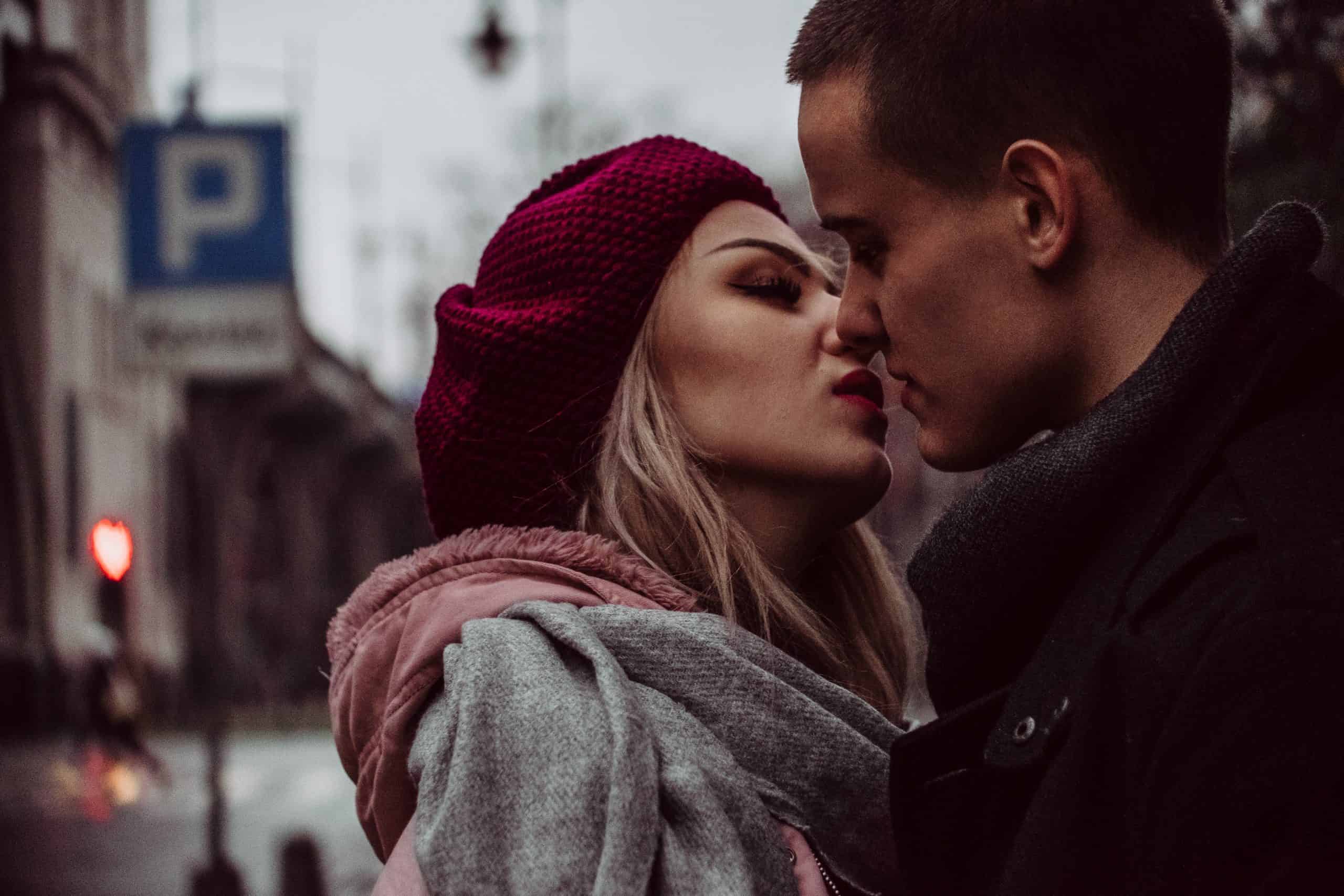 man och kvinna som kysser på gatan