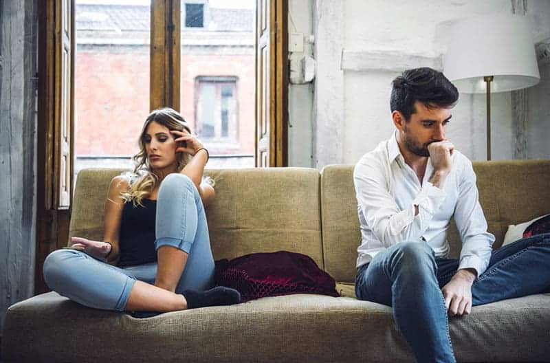 olyckliga par som sitter på soffan och ignorerar varandra efter kamp