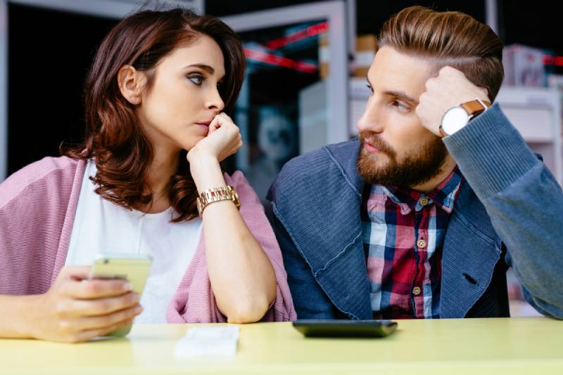 oroliga par som tittar på varandra på café