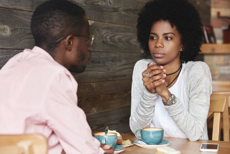 närbild porträtt av afroamerikanska vänner på caféet som har allvarliga konversationer