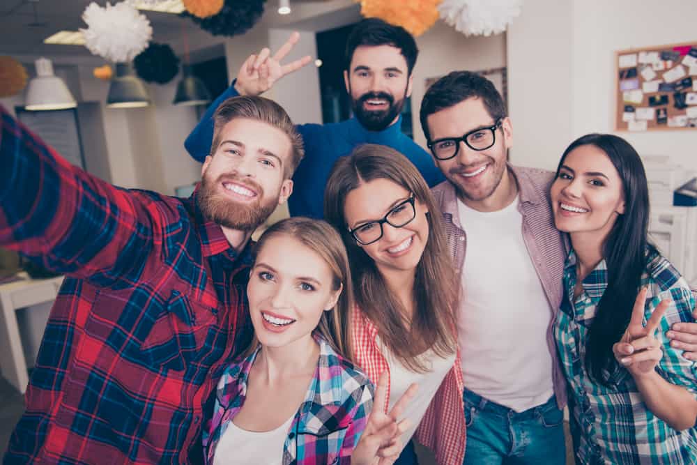 sex unga sorglösa attraktiva lyckliga vänner som gör v-tecken medan de gör selfie