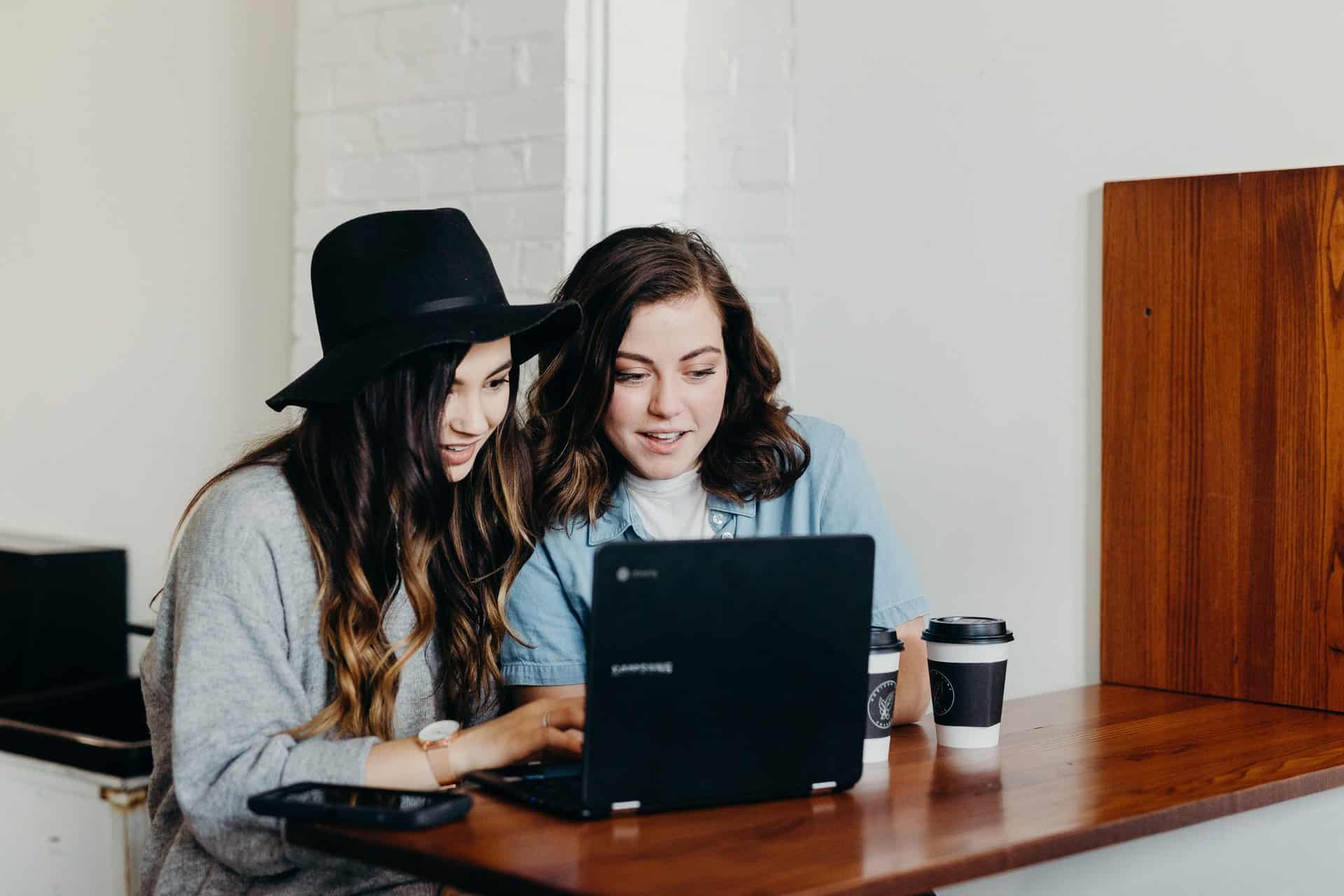 två kvinnor som använder bärbar dator